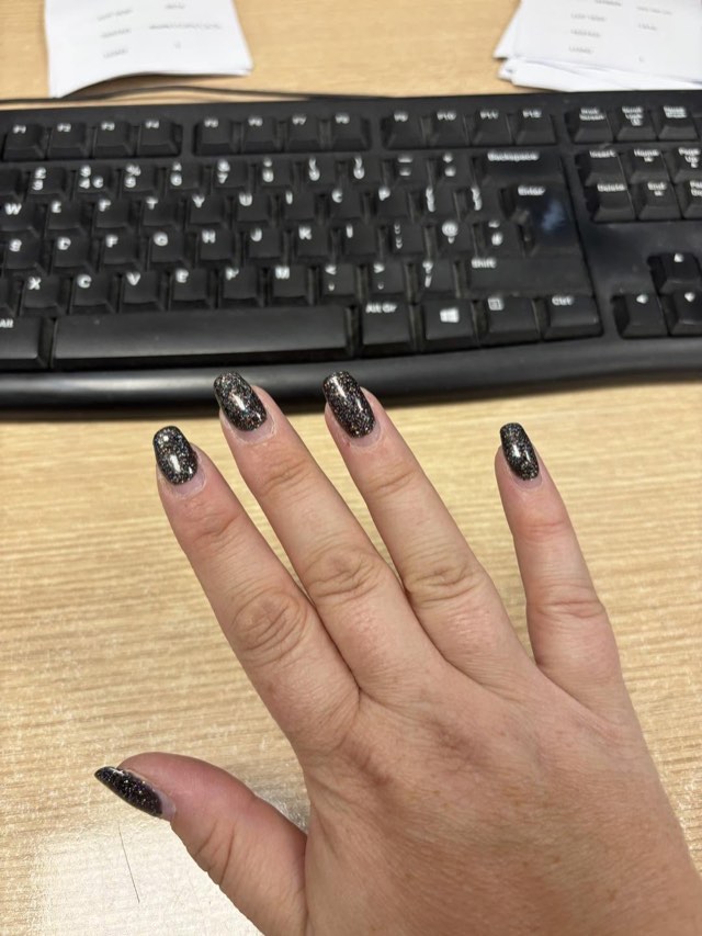 Almond nails in a dark shade with silver sparkle