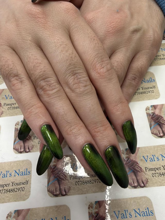 Long almond nails in a black and green cat eye gel