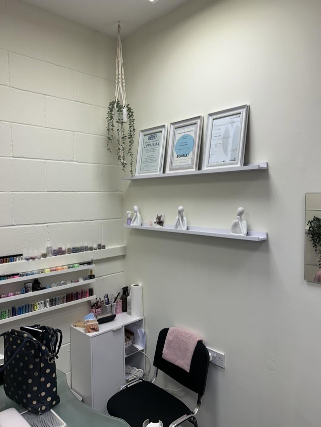 The treatment room at The Wellness Collective, with framed certificates on the wall